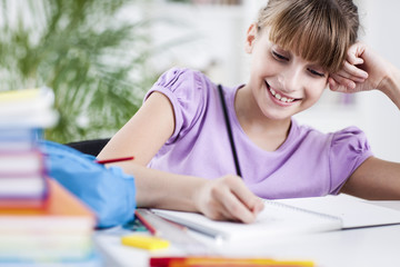 Smiling Girl Doing Homework at Home