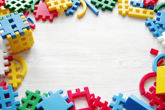 Color meccano on a white wooden surface. Children's background