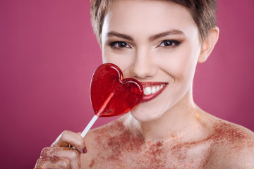 Joyful woman holding lollipop
