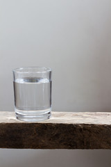 Drinking water in glass on a wooden floor.