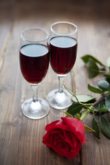 Rose and two glasses of wine on vintage background toned
