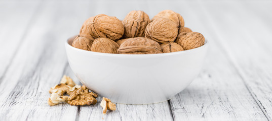 Whole Walnuts on wooden background (selective focus)