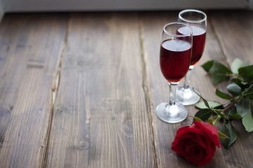 Rose and two glasses of wine on vintage background toned