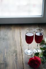 Rose and two glasses of wine on vintage background toned