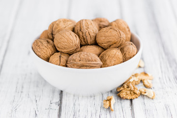 Portion of Whole Walnuts on wooden background (selective focus)