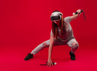 Excited woman using a VR headset isolated on red background