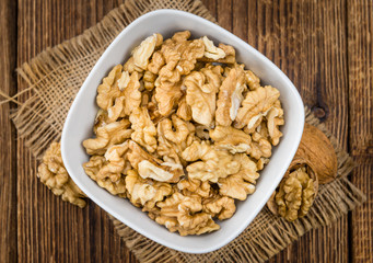 Portion of Cracked Walnuts on wooden background (selective focus