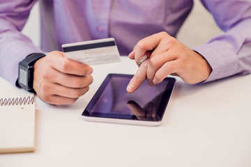 man shopping using tablet pc and credit card. Human hand on tablet