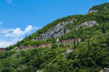 Fototapeta na wymiar View of Mountain with many buildings, city Varenna on Lake Como, Italy, Lombardy region. Italian landscape view