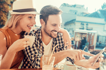 Young couple taking a photo of themselves in a cafe