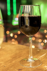 Glass of red wine on blurred lights background