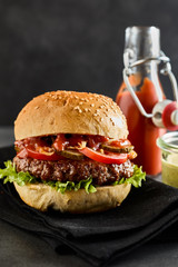 Close up of thick and juicy beef patty with tomato