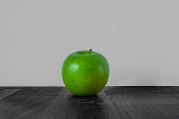 Still life of a vibrant green apple with black and white background