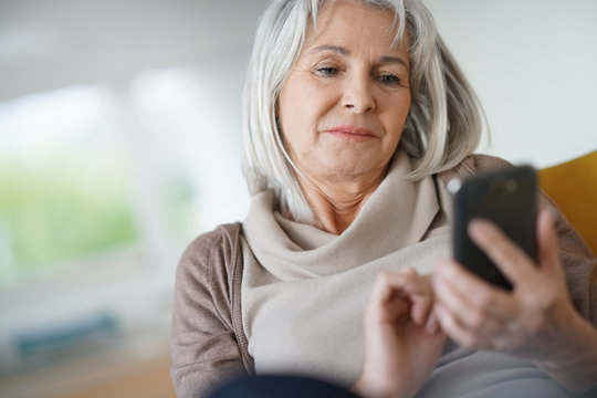 Senior woman relaxing and using smartphone