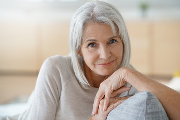Portrait of senior woman relaxing in sofa - Powered by Adobe