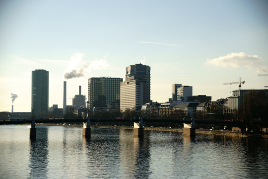 Hochhäuser an der Friedensbrücke Frankfurt / Hochhäuser wie der Westhafen Tower sowie Industrie an der Friedensbrücke und entlang des Flusses Main in Frankfurt.