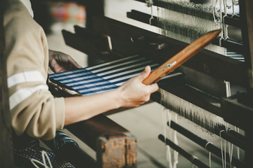 Woman hand weaving to make cloth fabric