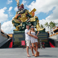 Tourist Couple Posing infront of Chinese Statue