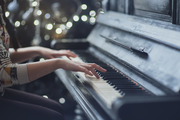 The girl plays piano, close up , white and black keyboard