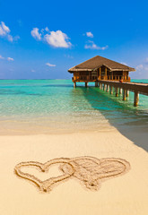 Drawing connected hearts on beach