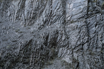 Fototapeta na wymiar Background from a dark and rough rock wall