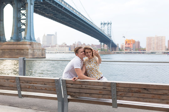Young Beautiful Couple Taking a Picture of Themselves in Brooklyn Bridge . New York City
