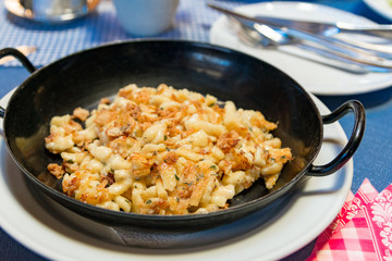 Käsespätzle rustikal serviert in einer nostalgischen Pfanne