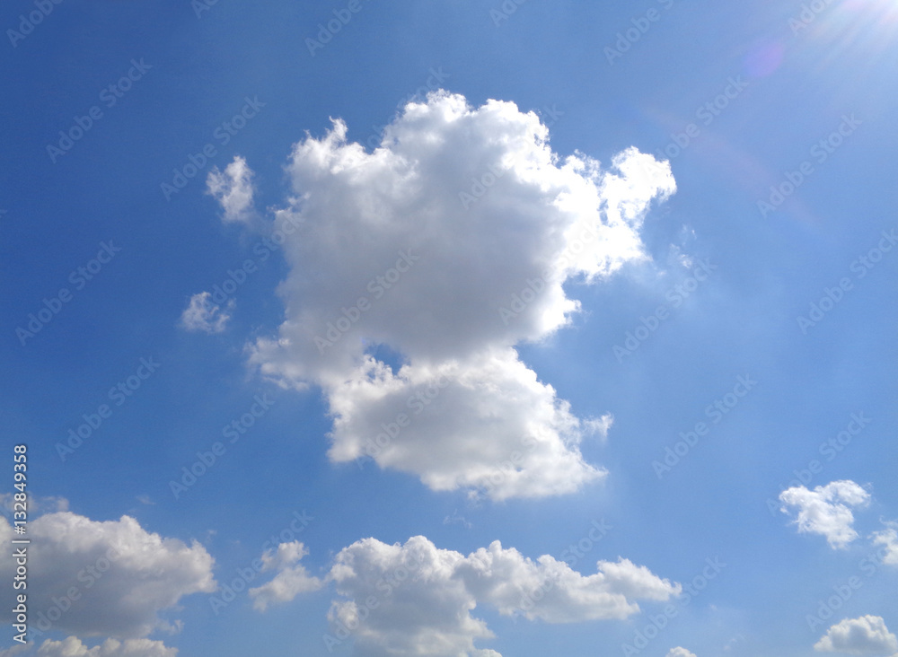 Wall mural white fluffy cloud floating on vivid blue sunny sky