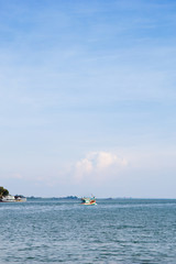 sky and sea with fisherman boat are driving out from the land