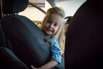 Small girl in car exhibition room