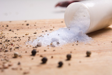 Pepper and salt on a kitchen wooden board