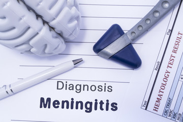 iagnosis meningitis. Figure brain, neurological hammer, printed on a paper blood test and written diagnosis of meningitis in the medical form is lying on the table in the doctor neurologist cabinet