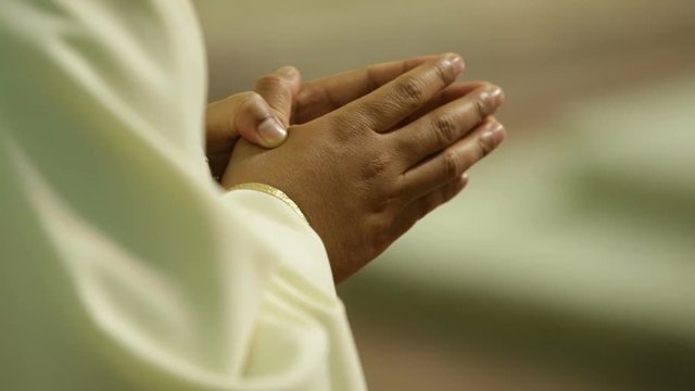 Mani di religiosi unite per la preghiera in chiesa