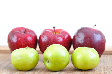 green and big red apples on wooden table