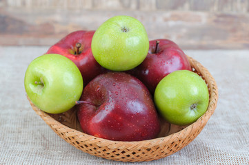 Fresh Apples in a wooden basket on wooden background