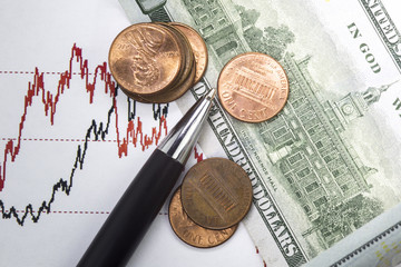 Stock market prices chart. Black and red lines of prices on the chart. Heap of one us cent coins near Hundred us dollar bill . one cent coins on the bill. Close up image
