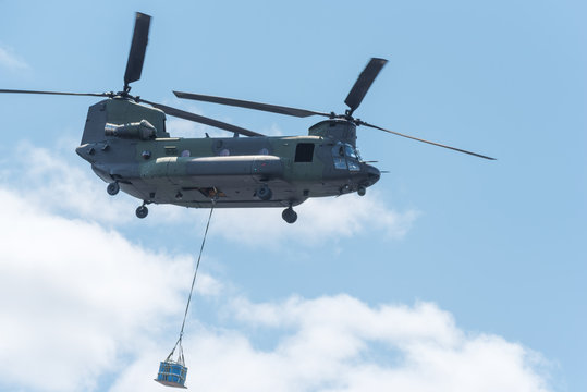 Double rotor, heavy airlift, military helicopter, in flight, carrying cargo.