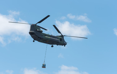 Double rotor, heavy airlift, military helicopter, in flight, carrying cargo. - 132856980