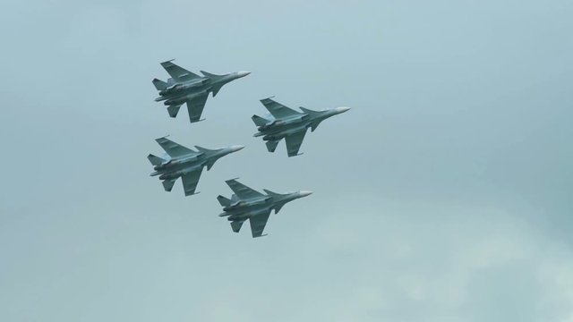 Four fighter jets flying close to each other in cloudy sky