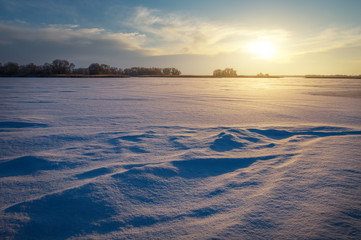 Beautiful winter landscape with lake and sunset sky. 