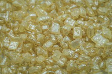 Closeup of yellow sprinkles made of sugar crystals. looks like precious gem stones