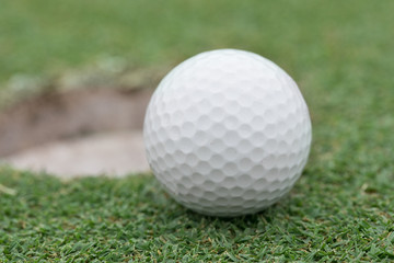 golf ball on lip of cup