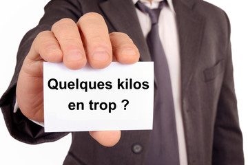 Homme tenant une carte avec écrit quelques kilos en trop