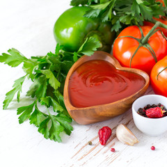 Tomato ketchup sauce in a wooden bowl and ingredients