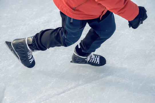 Close-up of ice skater's feet on ice rink