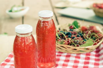 Two bottles of cold stewed fruit from assorted berries.