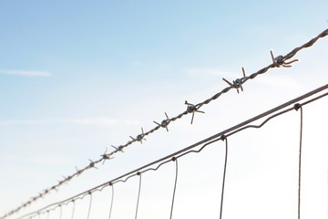 Barbwire in front of blue sky - selective focus