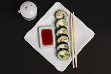 Top view of portion of chicken teriyaki rolls served on black pa