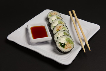 Angle view of portion of chicken teriyaki rolls served on black