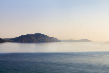 Serene wide open sea with cliffs in the distance